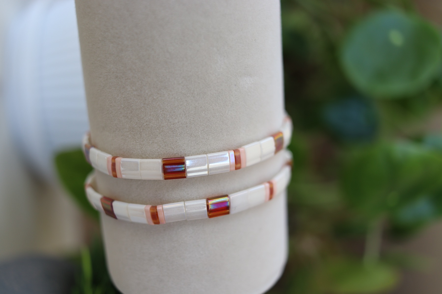 Owner-supplied photograph of two light-toned bracelets on a wrist